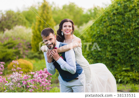 Bride hugs groom from the back on nature green Bride hugs groom from the back on nature green 38133531