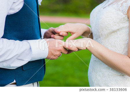 Close-up of groom holding hands of his bride Close-up of groom holding hands of his bride 38133606