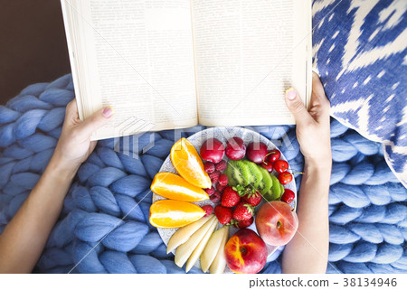 Plate with fresh fruit on a blue plaid and book Plate with fresh fruit on a blue plaid and book 38134946