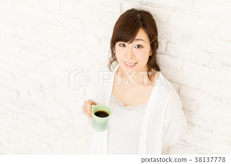 傾斜對牆壁的婦女飲用的咖啡 38137778