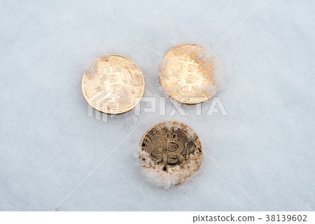 Gold coins bitcoin lie on white snow in winter Gold coins bitcoin lie on white snow in winter 38139602