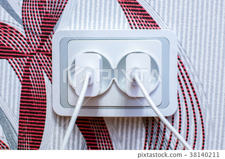cell phone chargers plugged into the socket cell phone chargers plugged into the socket 38140211