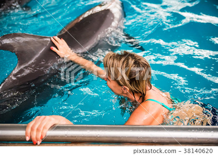 Woman swims with dolphin in dolphinarium 38140620