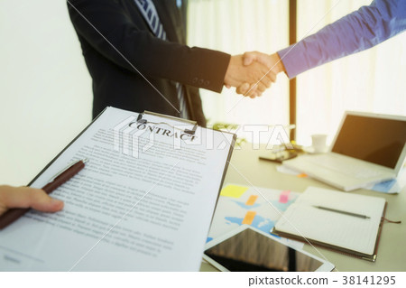 Two businessmen are shaking hands after agreeing Two businessmen are shaking hands after agreeing 38141295