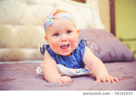 portrait of a half-year-old child lying on bed  38142033