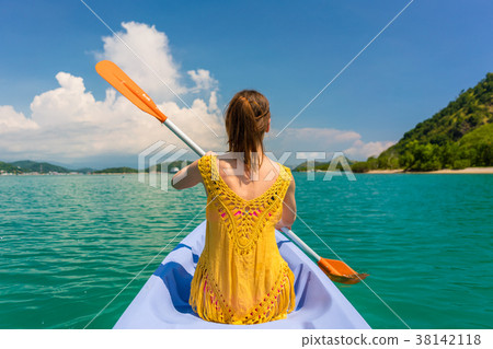 Young woman paddling a canoe during vacation in 38142118