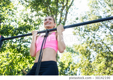 Cheerful young woman wearing pink sports bra while Cheerful young woman wearing pink sports bra while 38142190