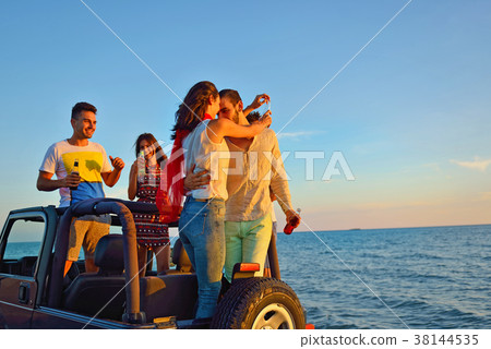 Group of happy friends making party in car - Young 38144535