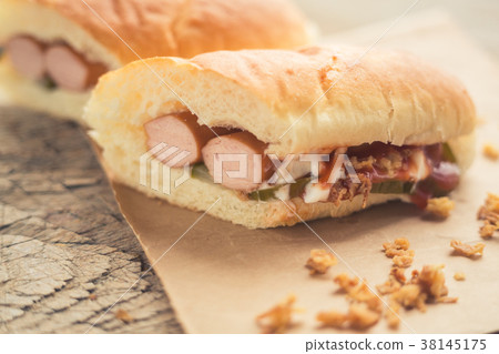 Hotdog with two sausiges and onion chips. 38145175