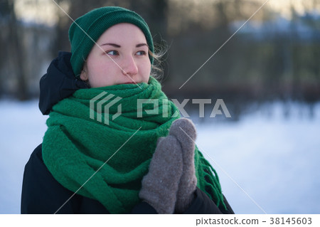 Teen girl warming hands in wool mittens in cold Teen girl warming hands in wool mittens in cold 38145603
