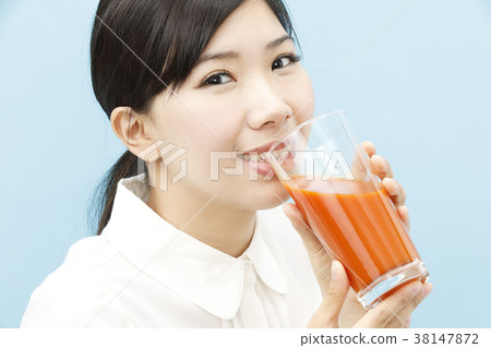 A young woman drinking vegetable juice A young woman drinking vegetable juice 38147872