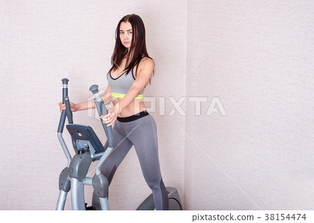 Young woman do exercises at home on the ellipsoid 38154474
