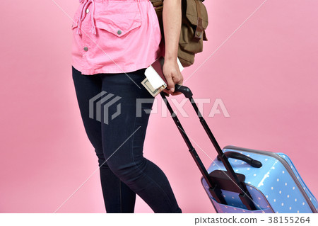 Traveler holding blue suitcase and passport. 38155264