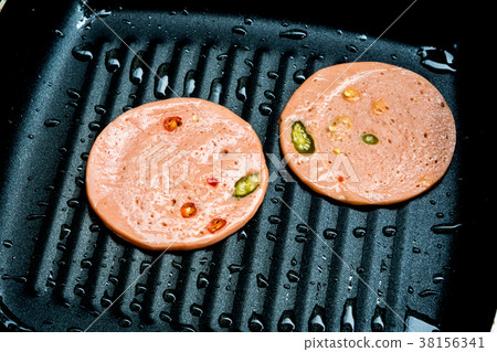 Spices ham fried in cooking pan Spices ham fried in cooking pan 38156341