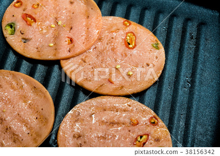 Spices ham fried in cooking pan Spices ham fried in cooking pan 38156342