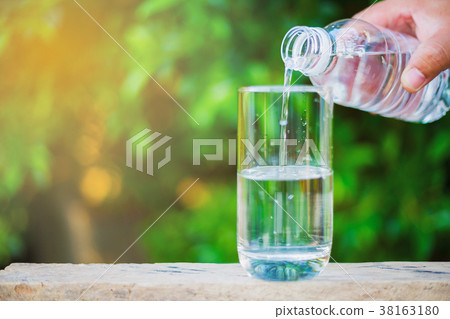 People are pouring water from a plastic bottle People are pouring water from a plastic bottle 38163180