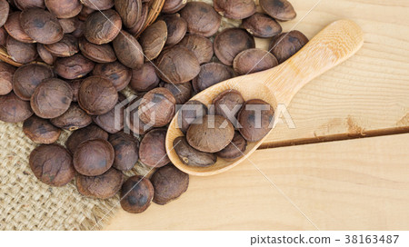 Sacha Inchi seeds in a spoon on a wooden table. 38163487