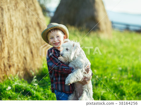 Boy embraces standing with dog, half-size portrait outdoor, hays 38164256