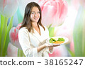 Young woman is holding plate of boiled vegetables 38165247