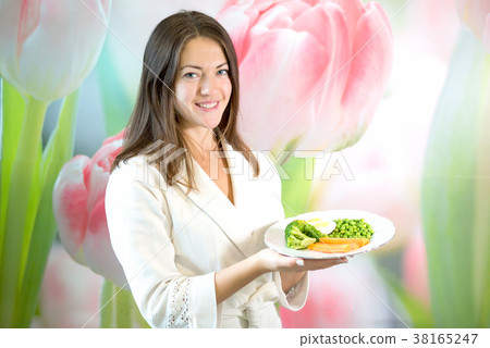 Young woman is holding plate of boiled vegetables 38165247