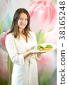 Young woman is holding plate of boiled vegetables 38165248