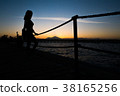 Silhouettes of girl standing on pier near the sea 38165256