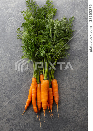 Fresh carrots bunch on stone countertop Fresh carrots bunch on stone countertop 38165276