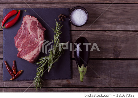Raw striploin steak with rosemary, salt, chili Raw striploin steak with rosemary, salt, chili 38167352
