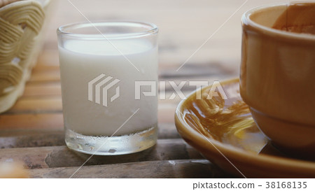 Milk and a cup of espresso on wooden table. 38168135