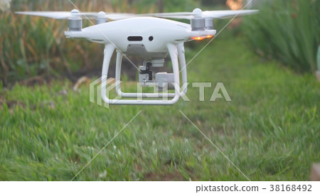 Hexacopter drone flies under grass in summer Hexacopter drone flies under grass in summer 38168492