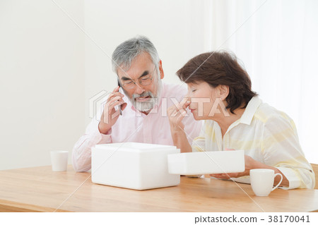 An elderly couple who is puzzled by opening a package Delivery problems Sending Herons Senior Silver Generation Grandpa and grandmother An elderly couple who is puzzled by opening a package Delivery problems Sending Herons Senior Silver Generation Grandpa and grandmother 38170041