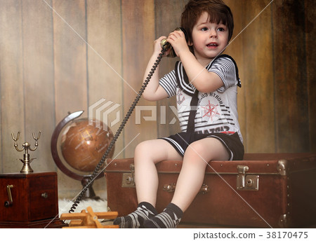 A child in a retro interior and an old phone sits A child in a retro interior and an old phone sits 38170475