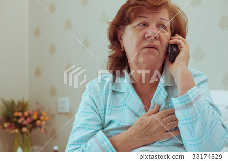 Sick aged woman calling her doctor. 38174829