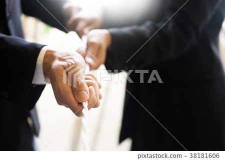 Hand pulling the rope, Grey background, cooperation concept as a 38181606