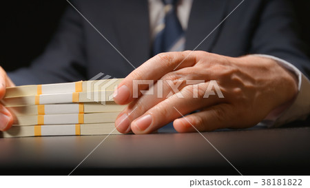 BRIBE: Businessman holds a money bundle at hands 38181822