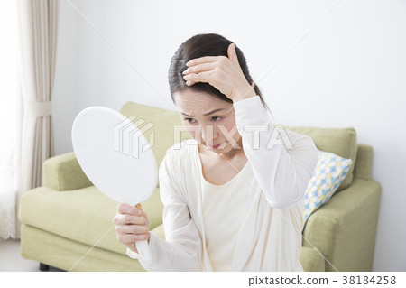 Fifties woman with hand mirror 38184258