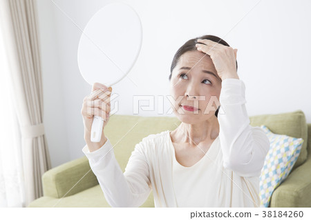 Fifties woman with hand mirror 38184260
