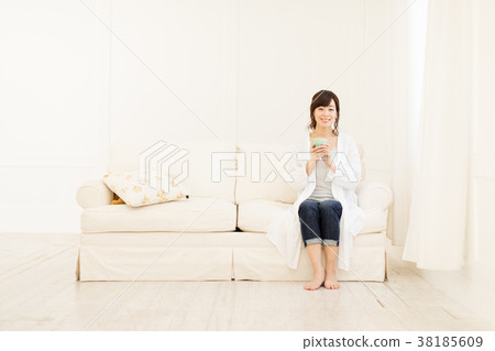 在沙發上的女人喝咖啡 在沙發上的女人喝咖啡 38185609