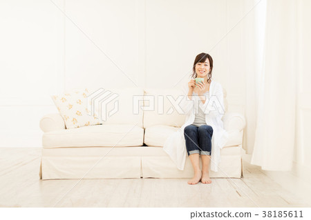 A woman drinking coffee on the sofa A woman drinking coffee on the sofa 38185611
