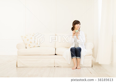 A woman drinking coffee on the sofa A woman drinking coffee on the sofa 38185613