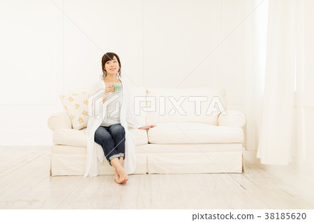 A woman drinking coffee on the sofa A woman drinking coffee on the sofa 38185620