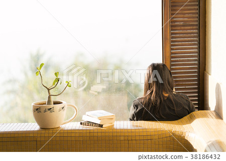 Books with plant and reader 38186432