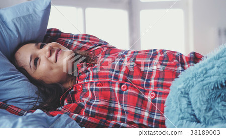 Sleepy young brunette happy woman lying in bed Sleepy young brunette happy woman lying in bed 38189003