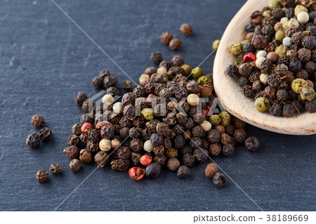 black pepper peas in a spoon on a stone background 38189669