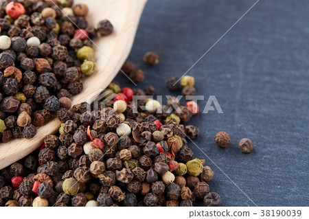 black pepper peas in a spoon on a stone background 38190039