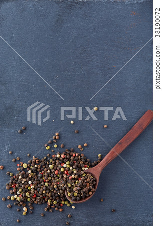black pepper peas in a spoon on a stone background black pepper peas in a spoon on a stone background 38190072