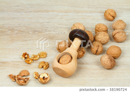 Wooden nutcracker in a mushroom shape and walnuts Wooden nutcracker in a mushroom shape and walnuts 38190724