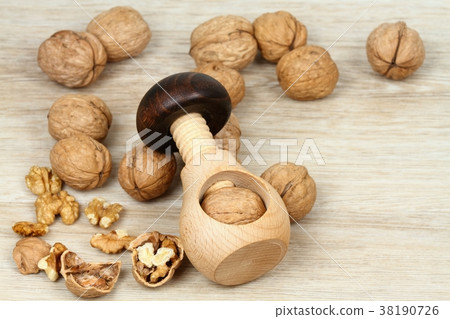 Wooden nutcracker in a mushroom shape and walnuts Wooden nutcracker in a mushroom shape and walnuts 38190726