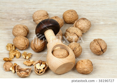 Wooden nutcracker in a mushroom shape and walnuts Wooden nutcracker in a mushroom shape and walnuts 38190727