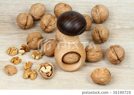 Wooden nutcracker in a mushroom shape and walnuts Wooden nutcracker in a mushroom shape and walnuts 38190728